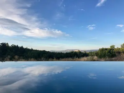 a view of a lake with trees and clouds at La Grisonne - Gîte Camus in Revest-du-Bion