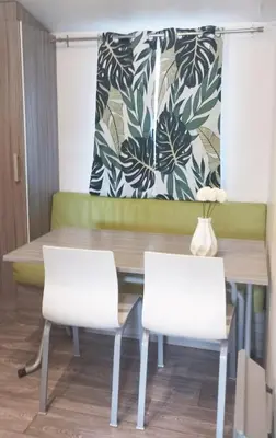 a dining room with a table and two chairs at Mobil Home vue sur le lac dans un camping 4 étoiles à Cadenet in Cadenet