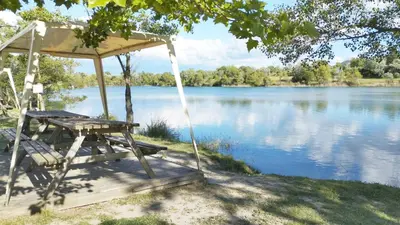 a large lake with trees in the background at Mobil Home vue sur le lac dans un camping 4 étoiles à Cadenet in Cadenet