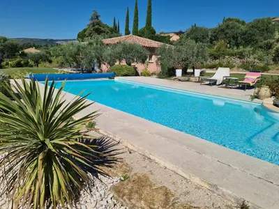 a swimming pool in a villa with a palm tree at Villa jeanne avec piscine Chauffée à Bedoin in Bédoin