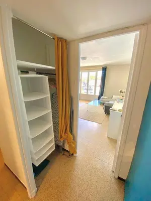 a room with a open closet and a living room at Charmant Appartement Proche Centre Balcon Belle Vue Cathédrale in Aix-en-Provence