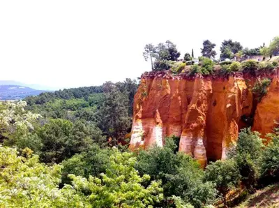 a large cliff with trees on top of it at Maison de campagne La Teranga au coeur du Luberon in Apt