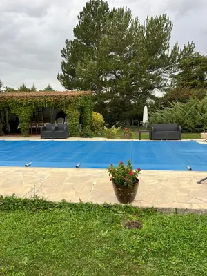 a pool with a blue tarp and a pot of flowers at La Port-Gentillaise in Aix-en-Provence