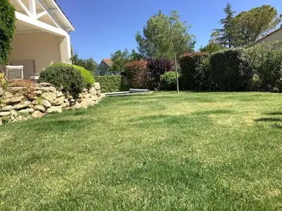 a yard with green grass and a house at PERNO LI FONT villa contemporaine avec piscine in Pernes-les-Fontaines