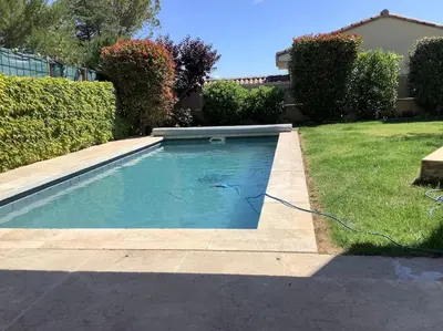 a swimming pool with a hose in the grass at PERNO LI FONT villa contemporaine avec piscine in Pernes-les-Fontaines