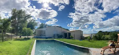 a pool in a yard with a building and a house at Maison au pied du mont ventoux in Carpentras