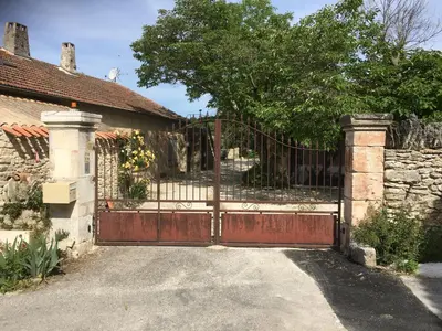 a gate to a house with a stone wall at Les Juliens in Gordes
