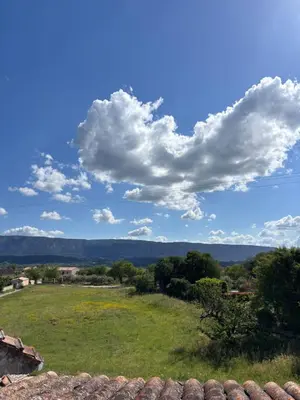 a view of a field with a blue sky and clouds at Les Juliens in Gordes