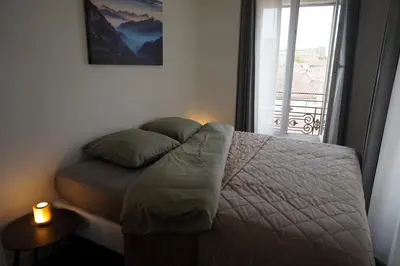 a bedroom with a bed with a candle and a window at Appartement Suite Privilège avec Parking in Salon-de-Provence