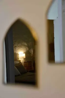 a reflection of a bedroom in a mirror at La loge familiale: 110m2, place rose goudard, AC in LʼIsle-sur-la-Sorgue
