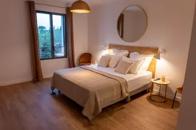 a bedroom with a large bed and a mirror at Comme à la maison in Châteauneuf-de-Gadagne
