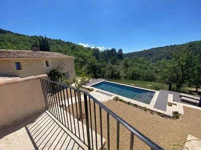 a house with a swimming pool in front of a mountain at Magnifique Mas avec Piscine Luberon (Gordes) in Murs