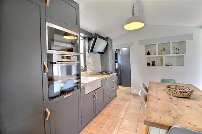 a large kitchen with a table and a counter top at Mazet avec piscine, vue Ventoux in Crillon-le-Brave