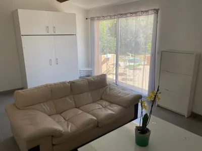 a living room with a couch and a large window at Studio charmant avec terrasse in Lançon-Provence