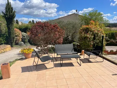 a patio with three chairs and a table and a bench at Studio charmant avec terrasse in Lançon-Provence