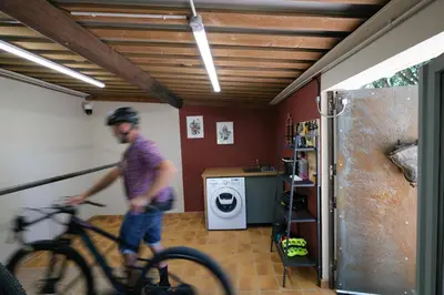 a man riding a bike in a living room at Rouleraventoux, Gîte sportif avec piscine, sauna, salle de sport, jardin in Mormoiron