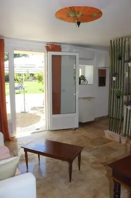 a living room with a coffee table and a large sliding glass door at Gîte la Cigale en pleine campagne in Carpentras