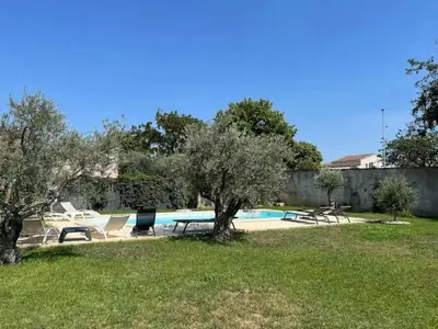 a backyard with a pool with chairs and trees at Villa charmante à Châteaurenard avec piscine privée in Châteaurenard