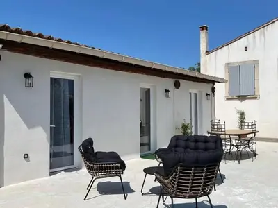 a patio with chairs and a table and a building at Villa charmante à Châteaurenard avec piscine privée in Châteaurenard