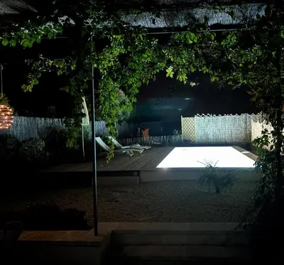 a garden lit up at night with a pool at Maison Plume en Provence in LʼIsle-sur-la-Sorgue