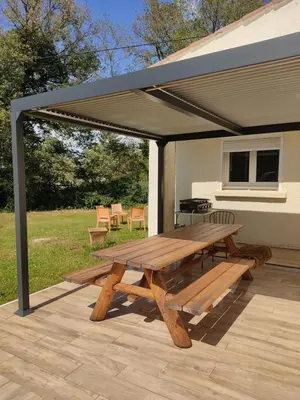 a picnic table under a canopy on a patio at Villa dans la forêt provençale in Jouques