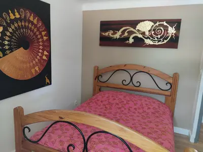 a bedroom with a wooden bed with pink sheets at Villa dans la forêt provençale in Jouques