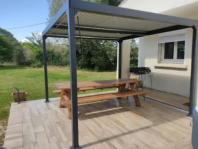 a picnic table under a canopy on a patio at Villa dans la forêt provençale in Jouques