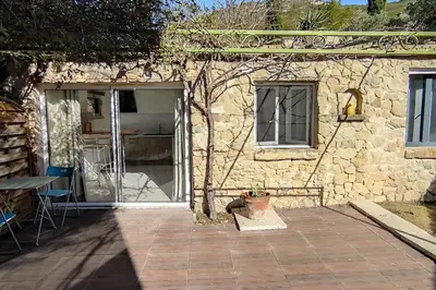 a stone house with a potted plant in front of it at Charmant studio indépendant dans la colline in Eyguières