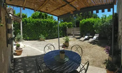 a patio with a blue table and chairs in a yard at Lou Pitchoun Cabanoun à Eygalières 