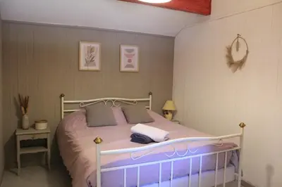 a bedroom with a bed with purple sheets and pillows at Lou Pitchoun Cabanoun à Eygalières 