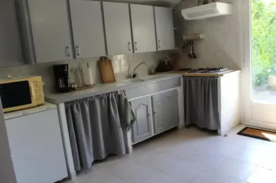a kitchen with white cabinets and a sink at Lou Pitchoun Cabanoun à Eygalières 