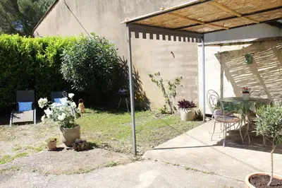 a patio with a table and chairs in a backyard at Lou Pitchoun Cabanoun à Eygalières 