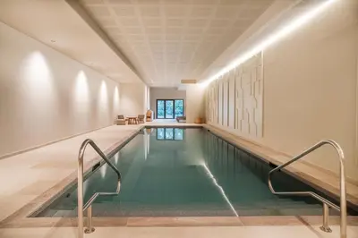 an indoor swimming pool with green water in a building at Setclub Hôtel & Spa Aix-en-Provence in Aix-en-Provence