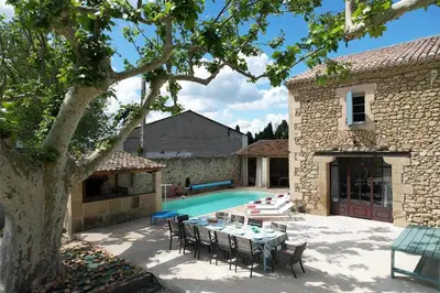 a patio with a table and chairs next to a pool at Provencal farm with heated pool in Lamanon near Aix en Provence - 12 people in Lamanon