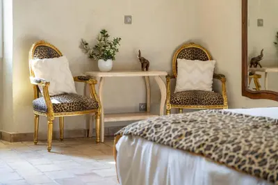 a bedroom with two chairs and a table and a bed at Provencal farm with heated pool in Lamanon near Aix en Provence - 12 people in Lamanon
