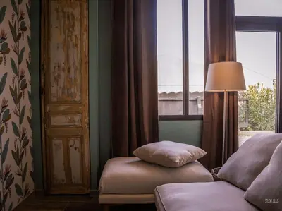 a bedroom with a bed and a lamp and a window at Charmant T1 calme et reposant in Saint-Andiol