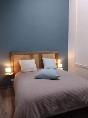 a bedroom with a bed with two pillows and two lights at Charmant T1 calme et reposant in Saint-Andiol