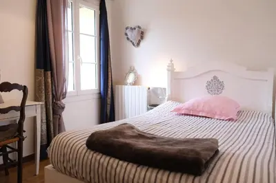 a bedroom with a large bed with a ottoman on it at Typical farm with private pool close to the Ventoux 8 persons in Althen-des-Paluds