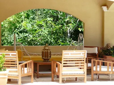 a patio with chairs and a table and a window at Typical farm with private pool close to the Ventoux 8 persons in Althen-des-Paluds