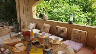 a table and chairs with a table and a window at Typical farm with private pool close to the Ventoux 8 persons in Althen-des-Paluds