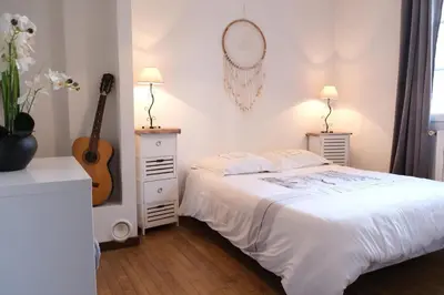a white bedroom with a bed and a guitar at Typical farm with private pool close to the Ventoux 8 persons in Althen-des-Paluds