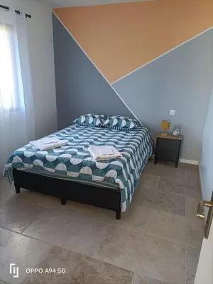 a bedroom with a bed with a blue and white comforter at Maison Neuf en Provence in Monteux
