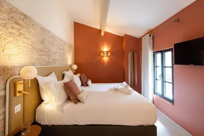 a bedroom with a large white bed with orange walls at Château la Beaumetane in Lançon-Provence
