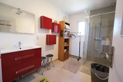 a bathroom with a sink and a shower with red cabinets at Air-conditioned house in the Luberon with heated swimming pool in Saint Saturnin les Apt - 8 people. in Saint-Saturnin-les-Apt