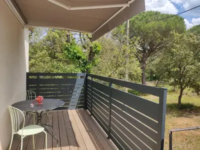 a patio with a table and chairs on a deck at Studio dans la forêt provençale in Jouques