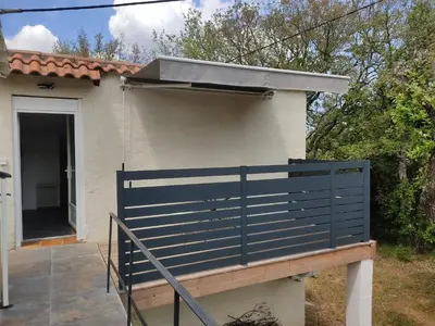 a blue fence in front of a house at Studio dans la forêt provençale in Jouques