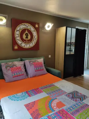 a bedroom with a bed with colorful pillows on it at Studio dans la forêt provençale in Jouques