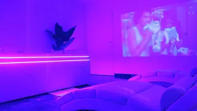 a room with red lights and a couch in a theater at DIMA SUITE Jacuzzi Privatif in Vedène