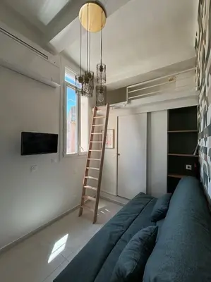 a room with a blue couch and a ladder at Studio Cosy au cœur d’Aix et & Cours Mirabeau in Aix-en-Provence