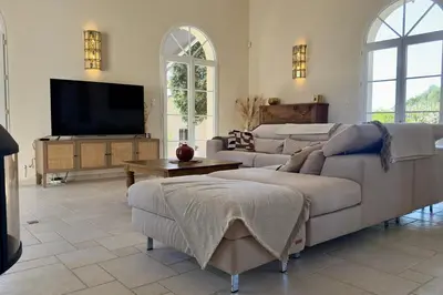 a living room with couches and a flat screen tv at Les Lauriers Roses air-conditioned villa with garden and swimming pool in Saumane-de-Vaucluse